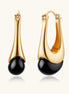 Gold-plated drop earrings featuring black agate stones with hoop closure on white background, showing elegant teardrop design.