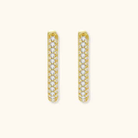 Close-up of small sterling silver huggie hoops completely covered in sparkling clear crystals with hinged closure