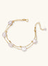 Double-strand gold bracelet with irregular baroque pearls and smooth freshwater pearls on cream background.