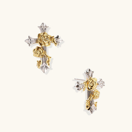 Gold-plated cross earrings with dimensional roses and crystal details on cream background, 18k gold over brass construction.