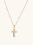 Gold-plated stainless steel cross necklace with crystal embellishments on adjustable chain against light background.