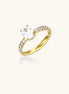 Gold-plated solitaire ring with oval zirconia center stone and pavé band on cream background