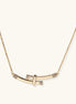 Gold-plated curved bar necklace with diamond accents on delicate chain against cream background