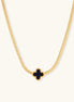 Dainty 18K gold-plated herringbone chain necklace with black enamel quatrefoil clover pendant on white background