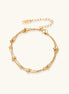 Three-strand gold-plated bracelet with clustered ball beads and adjustable clasp on cream background