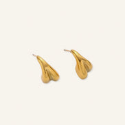 Organic sculptural gold stud earrings with fluid matte finish on cream background