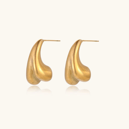 Organic sculptural gold stud earrings with fluid matte finish on cream background