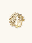 Gold-plated brass ring with sculptural petal-like elements in a wide band design on beige background