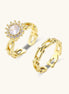 Two adjustable gold rings: chain-link band and halo-style ring with cubic zirconia stones on cream background