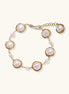 Gold wire-wrapped freshwater pearl bracelet with alternating pearl sizes on cream background, adjustable length