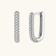 Close-up of platinum-plated sterling silver huggie hoops with pavé crystal setting on white background.