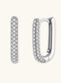 Close-up of platinum-plated sterling silver huggie hoops with pavé crystal setting on white background.