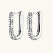 Close-up of platinum-plated sterling silver huggie hoops with pavé crystal setting on white background.