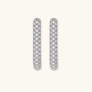 Close-up of platinum-plated sterling silver huggie hoops with pavé crystal setting on white background.